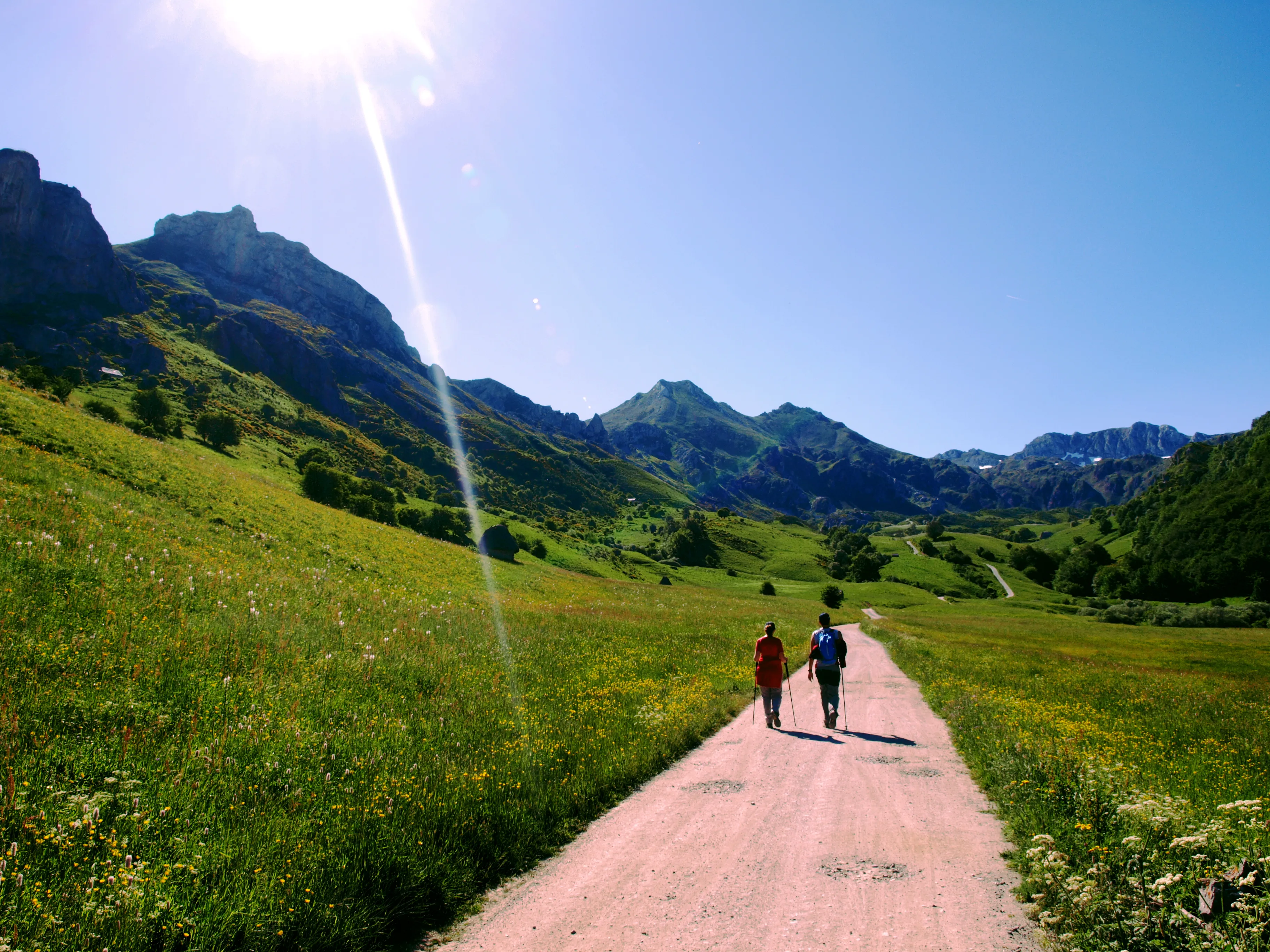 Senderistas recorriendo un sendero junto a un lago de montaña