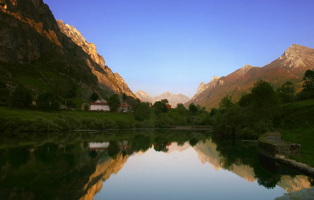 Lago de montaña al atardecer en el Valle de Somiedo con luz dorada